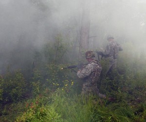Soldiers of the 442 Military Police Company use smoke to conceal their location while looking for an insurgent during a dismounted patrol on Fort Drum on June 10.